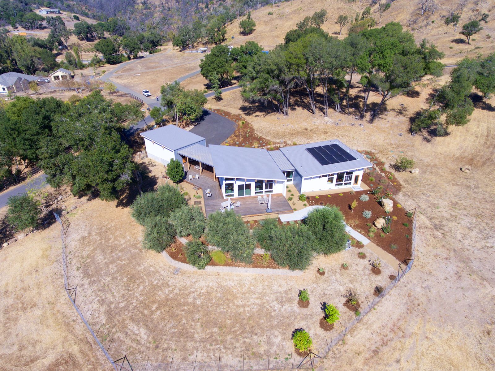 Aerial — hillside home nestled in the oaks