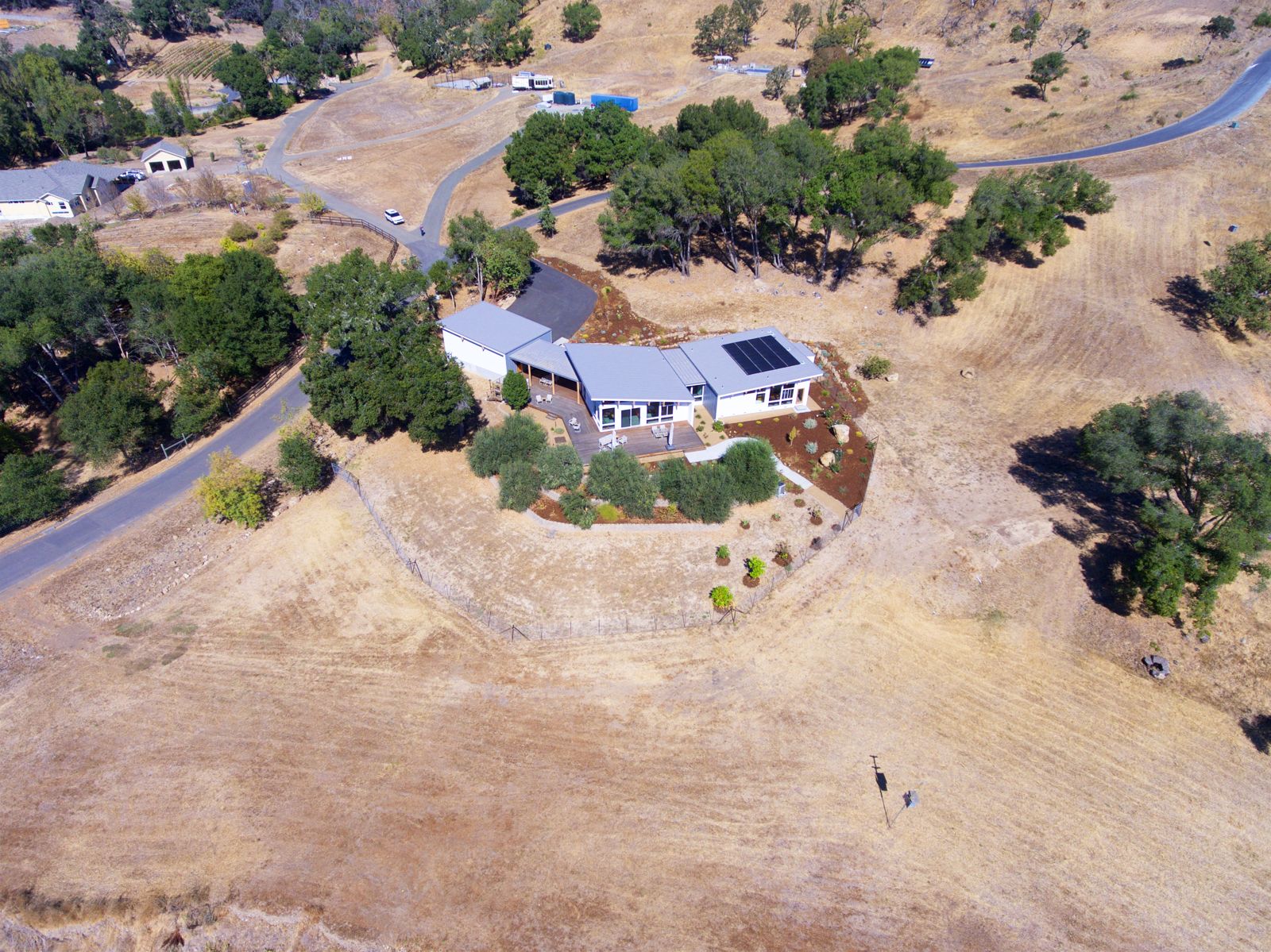 Aerial — completed hillside home with drive and new landscaping