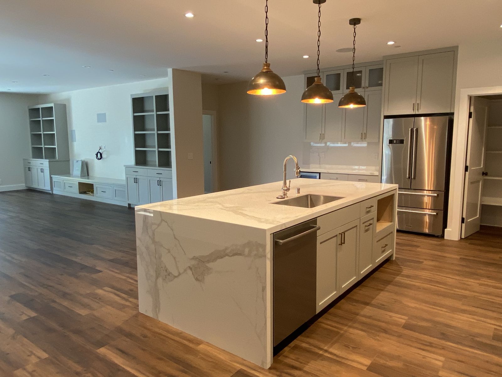 Full kitchen remodel — marble waterfall island and brass pendants