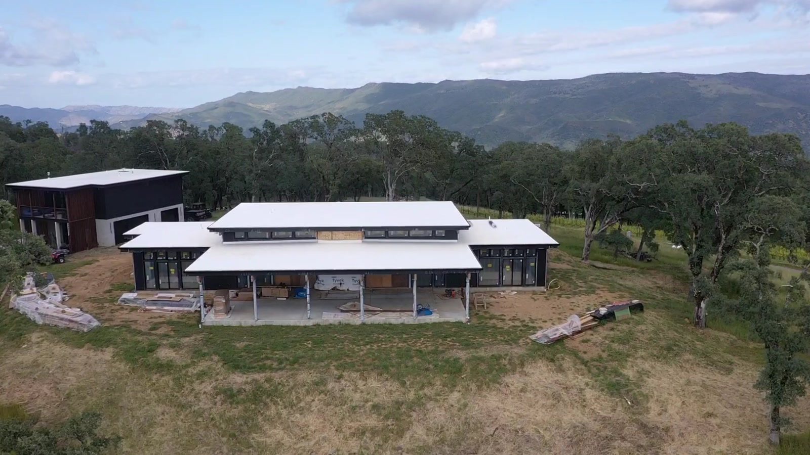 Lindal post-and-beam home under construction in Napa Valley, showing clerestory windows, deep covered porch and standing-seam roof, built by Howard Construction Inc.